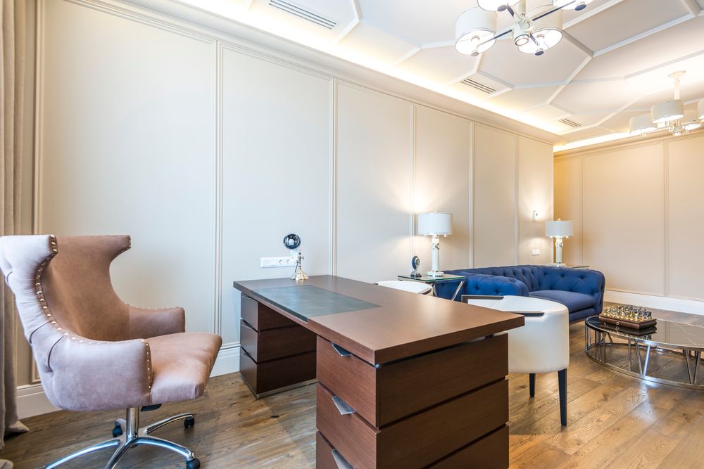 Bureau de direction élégant avec bureau en bois, fauteuil et coin salon, parfaitement entretenu