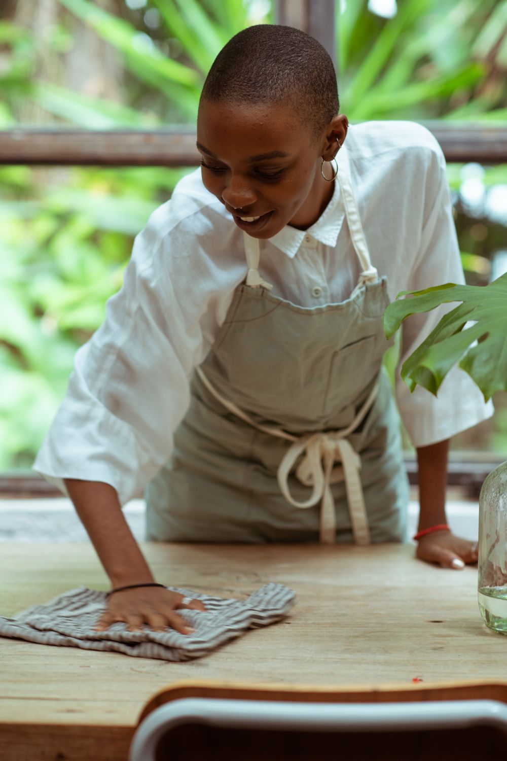 Femme souriante de Kleen-Net essuyant une table en bois après un événement